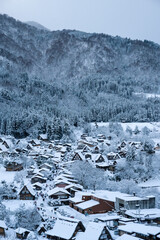 Fototapeta na wymiar Top view of traditional Houses (Gassho-style wooden houses) under cover by the snow after snow storm at Shirakawa-go historic village one of UNESCO's World Heritage Sites, Japan.