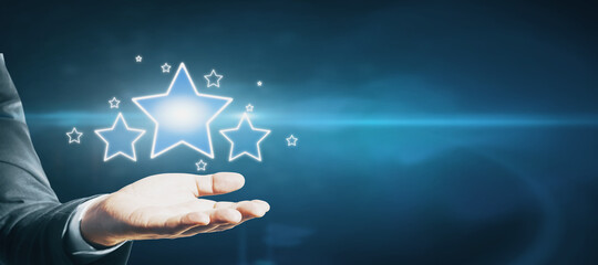 Hand holding glowing stars on blue background with mock up place for your advertisement. Customer...