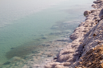 Totes Meer in Israel mit Salzsteinen klarem Waser Spiegelungen und einem Steg