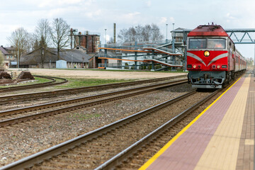 Fototapeta premium Railroad tracks and red locomotive in the town.old train locomotive.