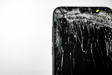 Mobile phone with broken screen on white background.Close-up.Copy space.