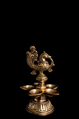 Indian traditional bronze oil lamp in the form of a bird on a black background. Metal diya. traditional Indian religious ceremony of Hindus. Diwali.