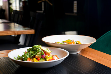 Buckwheat dumplings with fresh mushrooms and vegetable salad with cheese, fresh romatoes and cucumbers in restaurant.