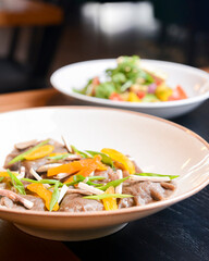 Buckwheat dumplings with fresh mushrooms and vegetable salad with cheese, fresh romatoes and cucumbers in restaurant.