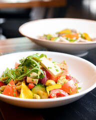 Buckwheat dumplings with fresh mushrooms and vegetable salad with cheese, fresh romatoes and cucumbers in restaurant.