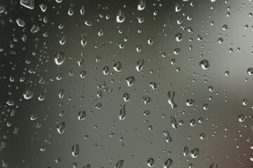 Water drop, rain drops on glass and dripping down