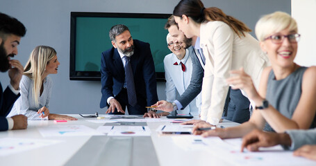 Portrait of happy business people discussing together in office