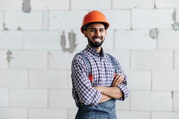 building, construction and people concept. Builder crossed hands in gloves at construction