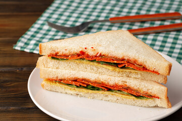 Double club sandwich served on plate on wooden table