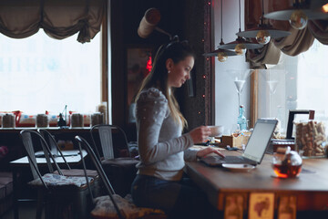 Hands of a woman working on a laptop. A freelance worker completes an order in a cafe.