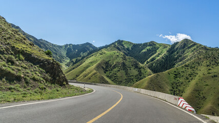 Highways with mountains and grasslands in Xinjiang, China in summer