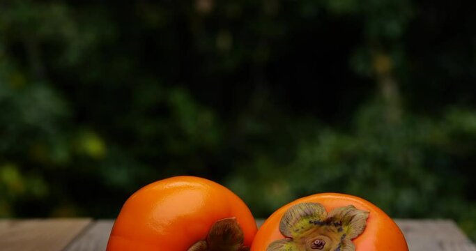 Tilt-down video of persimmons on a wooden board.