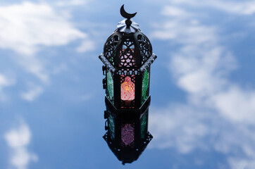 Selective forcus of lantern with reflection blurred background of cloud and sky for Islamic new...