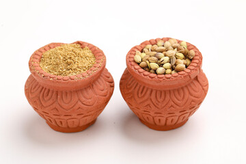 coriander seed and powder in clay bowl on white background.