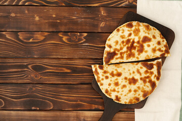 Baked homemade flatbread on wooden background close up