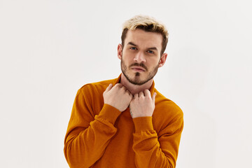 a man with a serious expression holding his collar looking forward