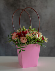 a beautiful bouquet in a festive pink package on a gray background