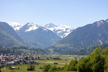 Wunderschöne Aussicht in den Alpen über ein Dorf mit Ausblick und ein wenig Schnee