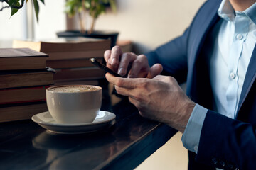 man with a phone in his hands sitting in a cafe leisure work lifestyle businessman
