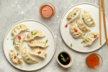 Dumplings Jiaozi Gyoza steamed on white plates with soy sauce and chili sauce. Food Takeout takeaway, home delivery