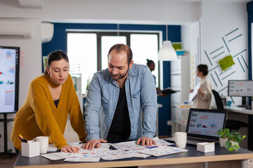 Multiethnic leadership of start up company office working on important project. Diverse team of business people analyzing company financial reports from computer.