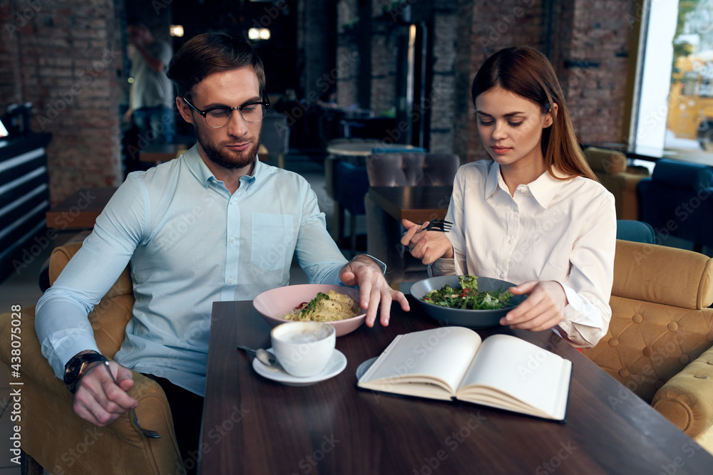 Wall mural business men and women sit at the table with the phone chatting breakfast