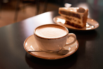 Cup of cappuccino and piece of cake 