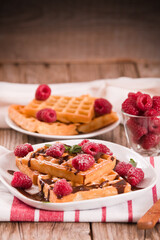 Waffles with raspberries and chocolate cream.