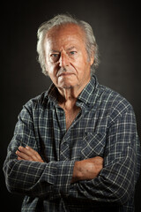 Studio portrait of an aged powerful, rugged man. Black backround