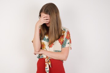 Indoor portrait of beautiful woman with stylish haircut, wearing casual clothes, making facepalm...