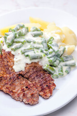 pork meat with cream sauce of green beans and cooked potatoes