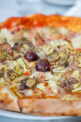 homemade pizza with ham, olives and artichoke
