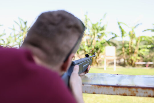 Man shoots a weapon at target in street shooting range