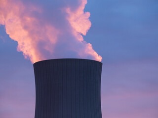 Nuclear power plant against sky at sunset