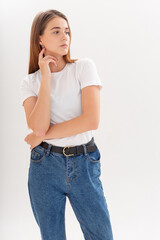 portrait of young attractive caucasian woman with long hair in t-shirt and blue jeans isolated on white studio background. skinny pretty female posing on cyclorama. model tests of beautiful lady