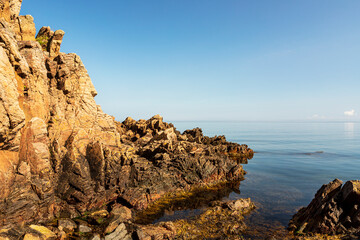 Rock formations by sea against clear sky