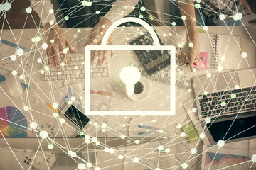 Double exposure of man and woman working together and lock hologram drawing. Security concept. Computer background. Top View.