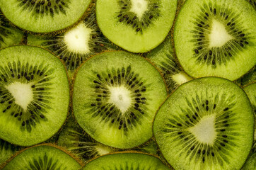 many slices of juicy ripe kiwi as a textured background. tropical fruit