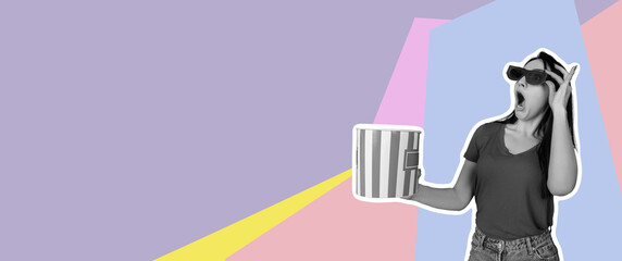 Woman hand holding striped bucket with popcorn isolated on red background