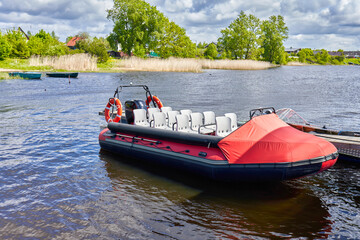Fototapeta premium A tourist open boat is moored to the pier in the bay