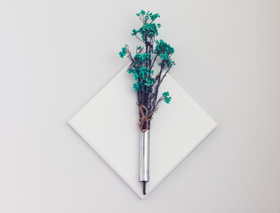 decorative element of a modern minimalstic iterior design. Floral branch on a white wooden plte placed over the grey wall.