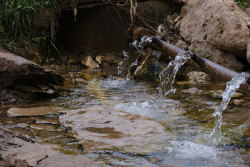 Spring water flowing out from under the hill. Spring Islam, Aktobe, Kazakhstan. The nature of Kazakhstan. Tourism in Kazakhstan.