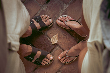 Top down view of man and woman wearing sandals and flip flops facing eachother. Summertime,...