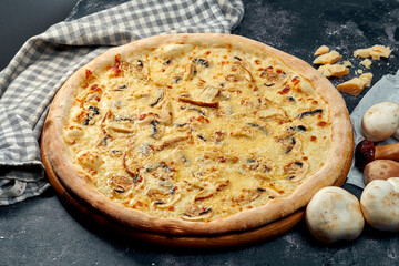 Appetizing pizza with different types of mushrooms, mozzarella and parmesan, white sauce. Dark background. Italian Cuisine