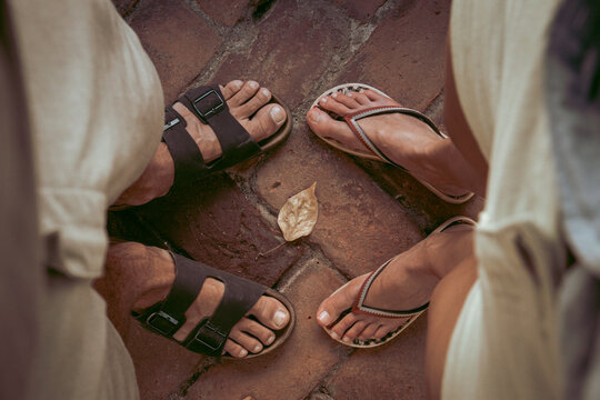 Top down view of man and woman wearing sandals and flip flops facing eachother. Summertime, adventure, backpacking, traveling concept.