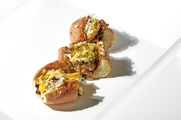 Cutted Classic cheese steak with pork, pickled cucumbers, onions, cheddar and mozzarella. White background. Hard light