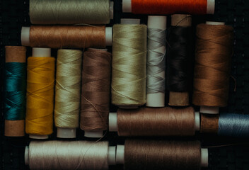 Retro sewing items: tailoring scissors, cutting knife, thimble, wooden thread spools, cushion for...