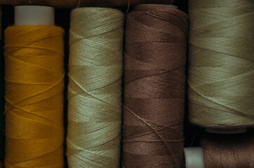 Retro sewing items: tailoring scissors, cutting knife, thimble, wooden thread spools, cushion for...