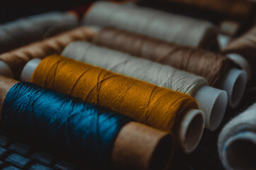 Retro sewing items: tailoring scissors, cutting knife, thimble, wooden thread spools, cushion for...