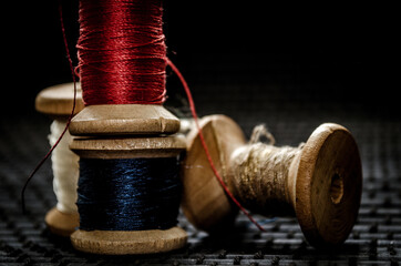 Retro sewing items: tailoring scissors, cutting knife, thimble, wooden thread spools, cushion for...